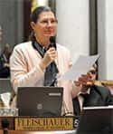 Barbara Fleischauer holding a mic reading off a paper