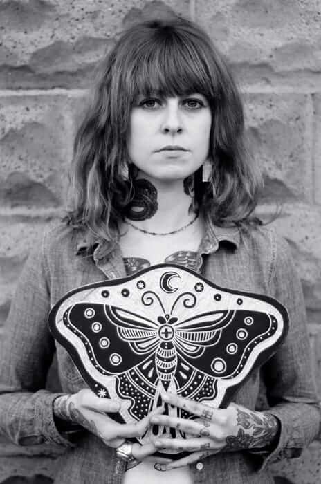 Bryn Perrott holding a piece with a butterfly