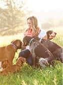 Chelsea Stanley surrounded by dogs varying in breeds and sizes