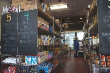 a home brewed grocery store with hand-made signs and stocked shelves