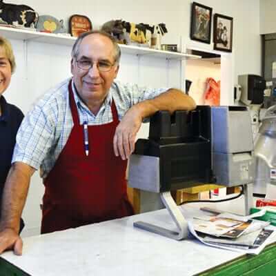 Ralph and Janet Richmond standing near a meet slicer