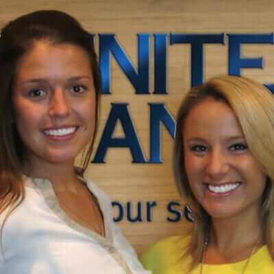 Abby Monson and Blair Trout pose in front of the United Bank sign