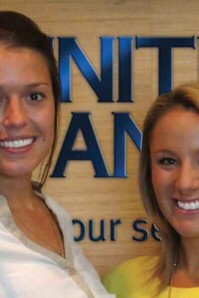 Abby Monson and Blair Trout pose in front of the United Bank sign