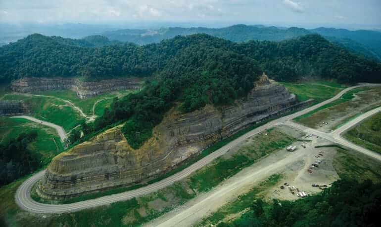 Arial view of a mountain with a road winding around it.